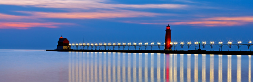 picture of Grand Haven Pier Lighthouse after sunset with pink clouds in the distance