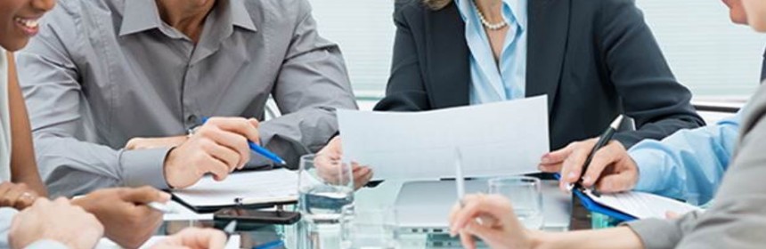 businesspeople sitting around a table reviewing documents