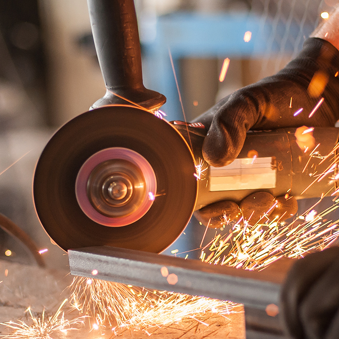 Electric wheel grinding on steel structure in factory